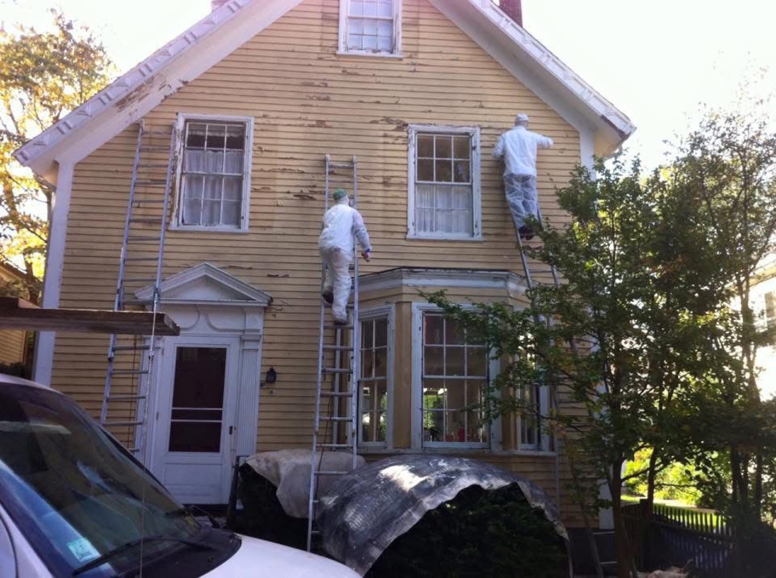 Exterior house painting prep with painters on ladders