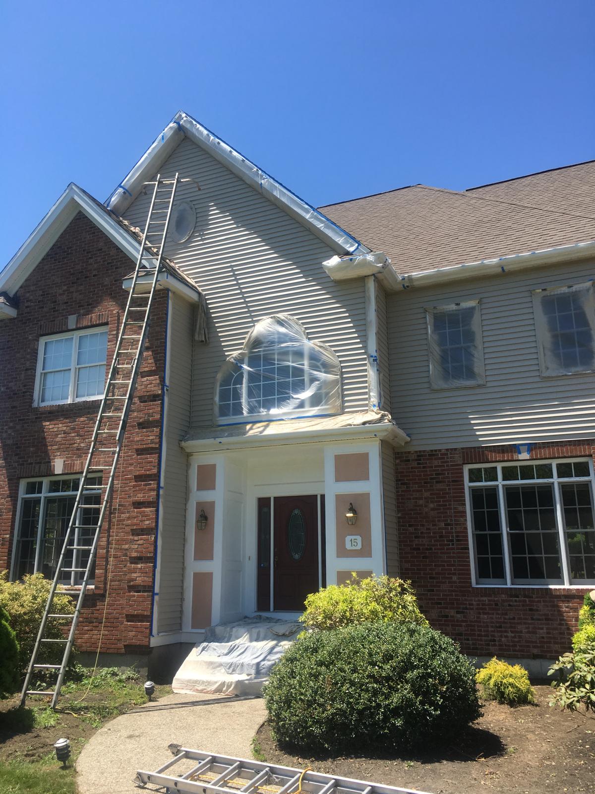 House prepped with masking and ladders mid-job